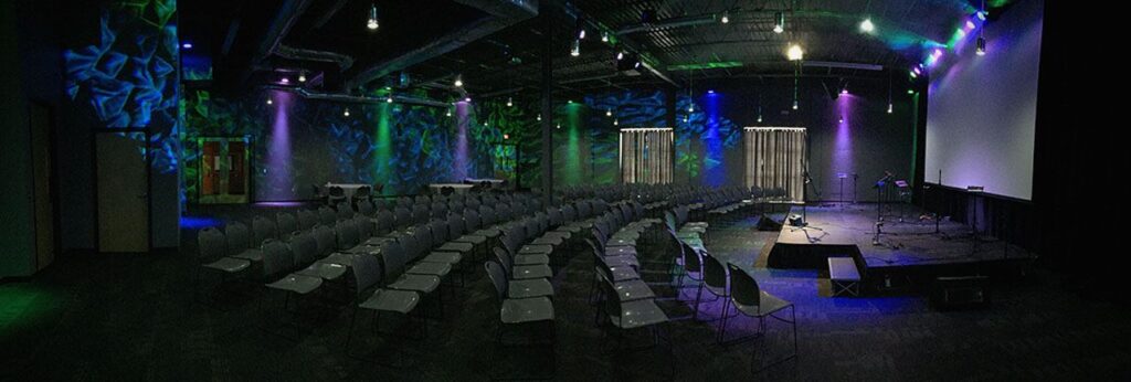 Tables and chairs set up in front of a stage.