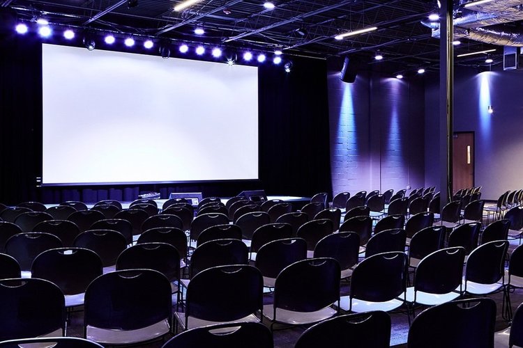 A theater with a large presentation screen and seating.